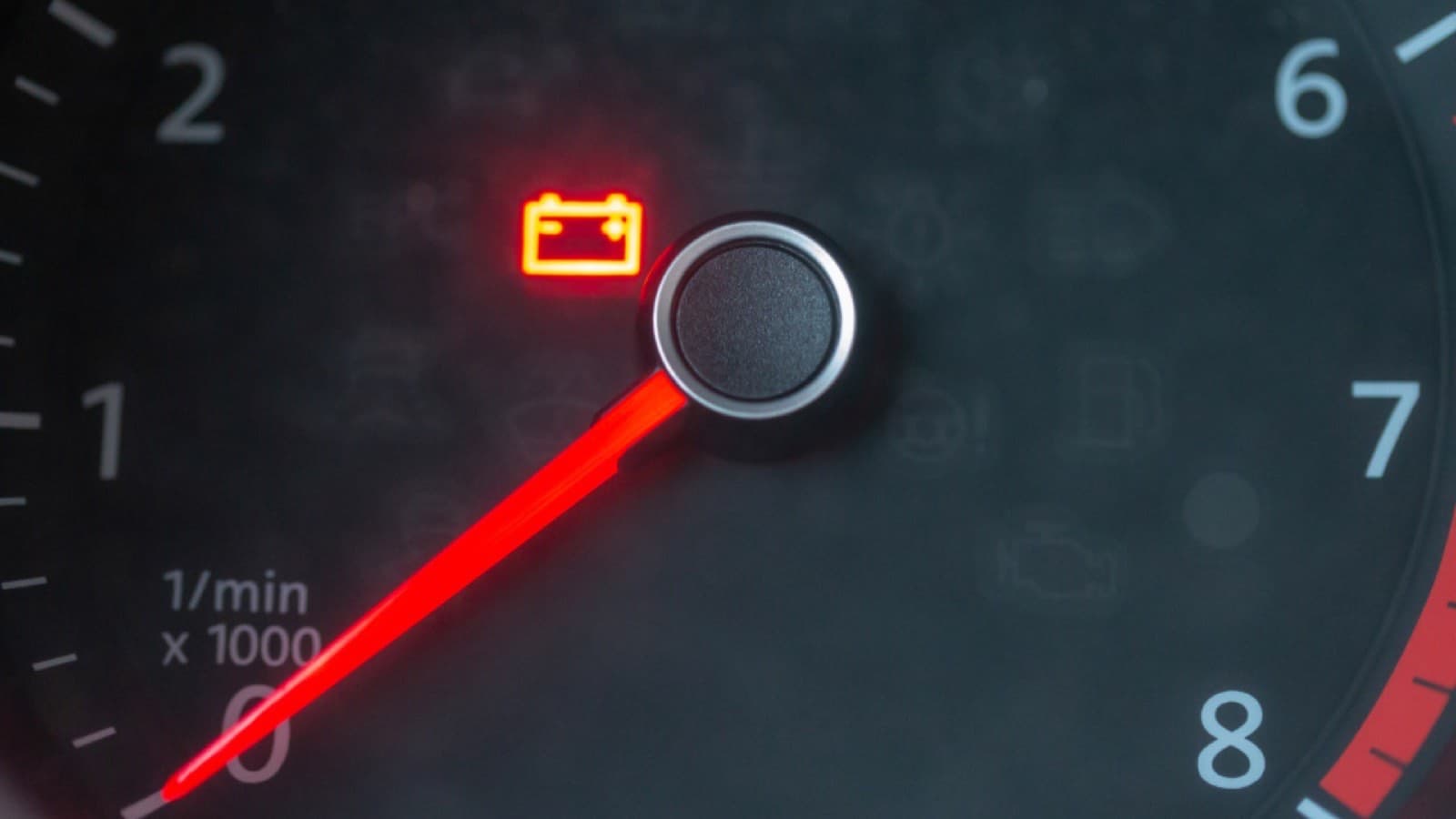 A car speedometer and instrument dials lit on a dashboard