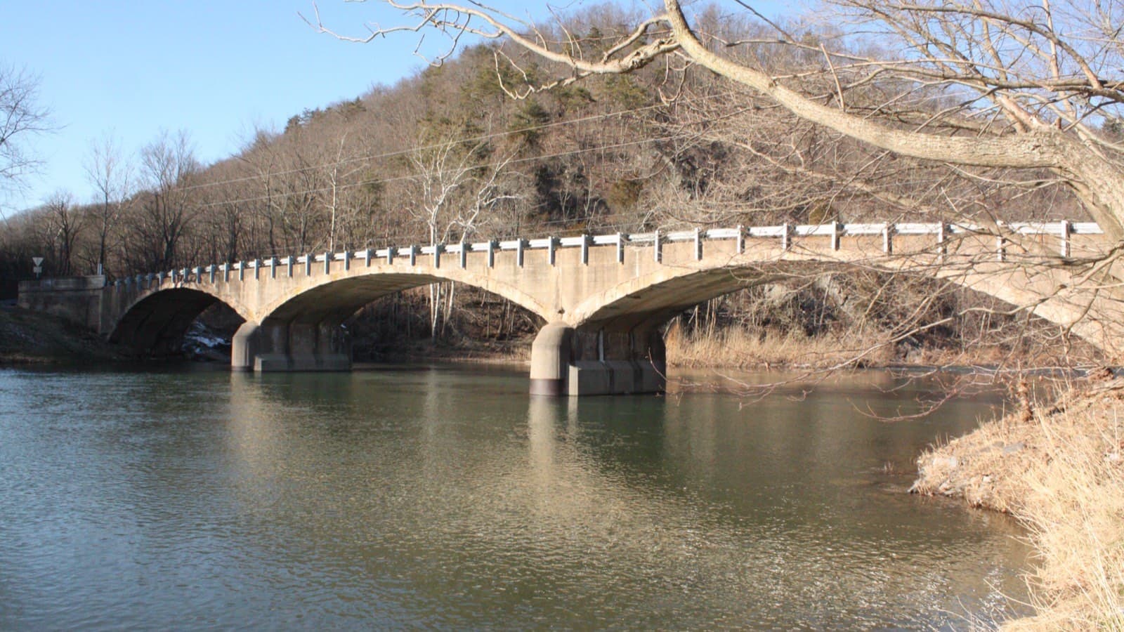 A metal guardrail running along the edge of a bridge