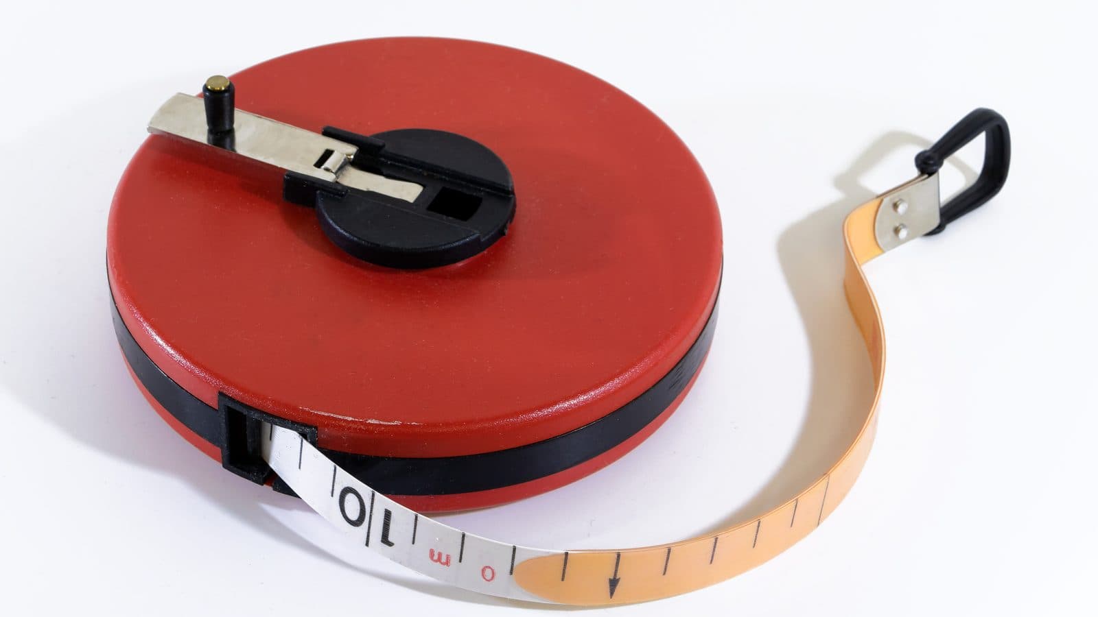 A retractable tape measure extended on a white surface