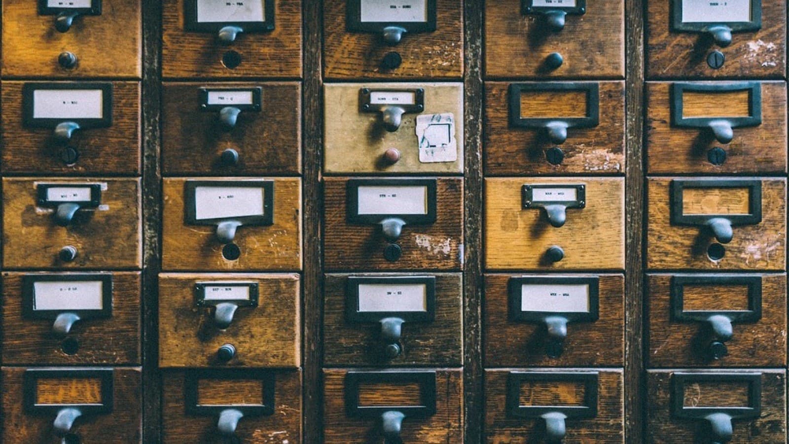 Drawers of a library card catalog filled with index cards