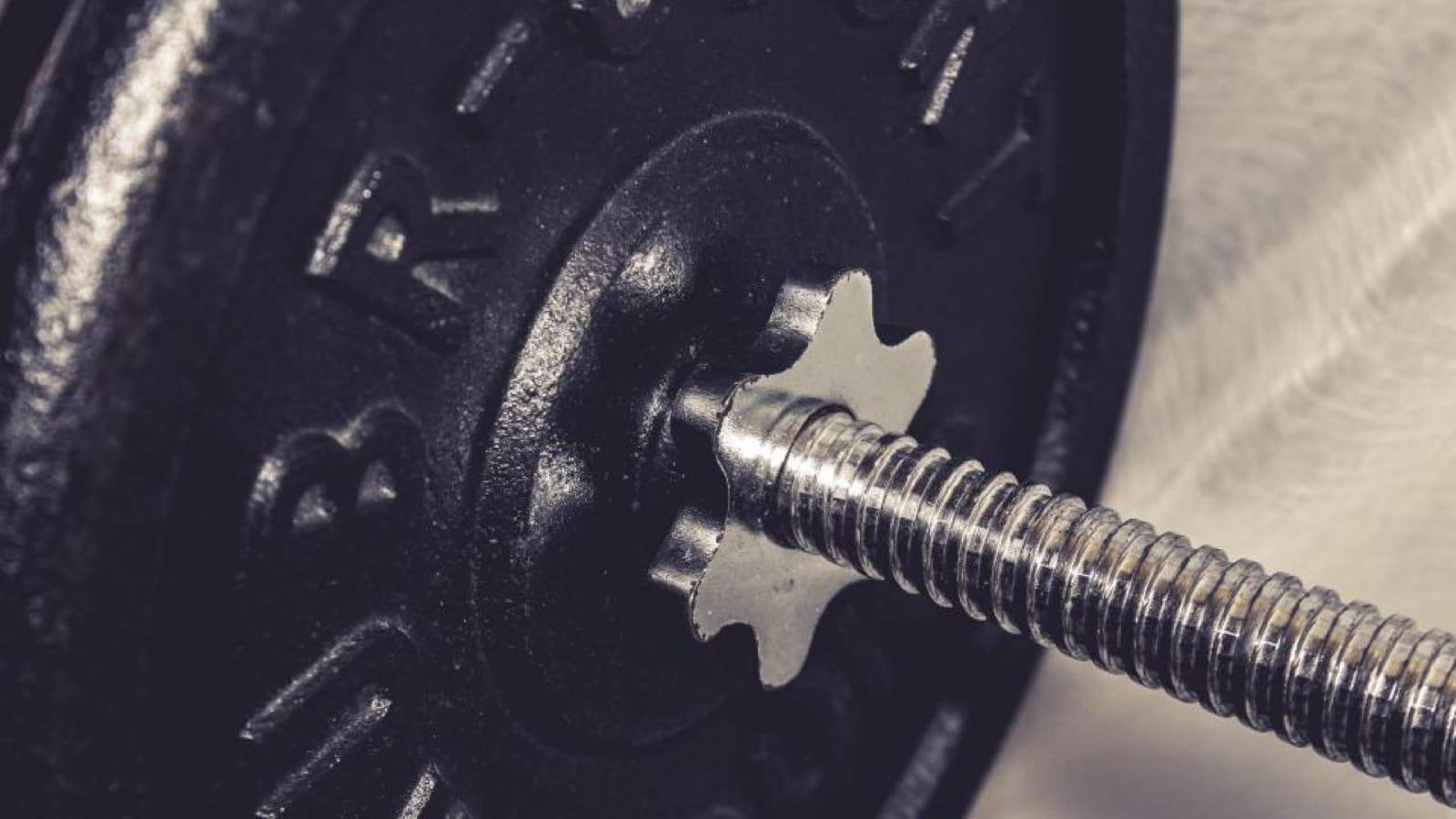 A cast-iron weight plate on the threaded end of a barbell