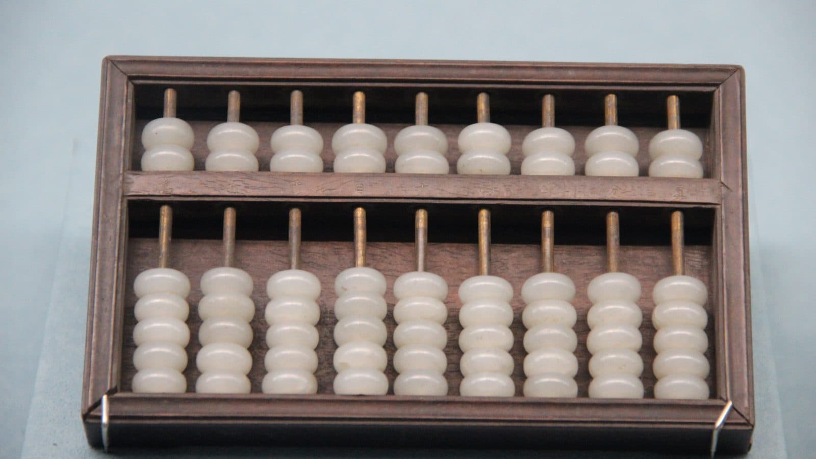 A wooden abacus with jade beads arranged on rods