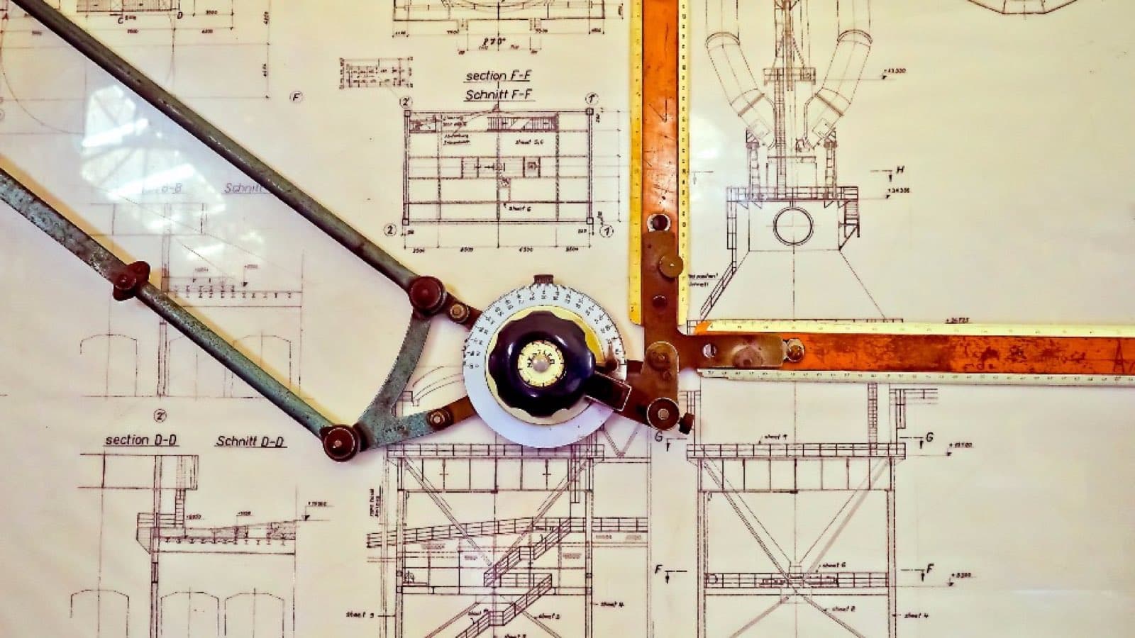Engineering drawings of a structure, overlaid with a metal ruler and a protractor